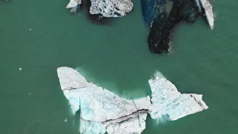 sobrevuelo bajo de icebergs en jokulsarlon con ángulo de cámara recto hacia abajo, vuelo rápido