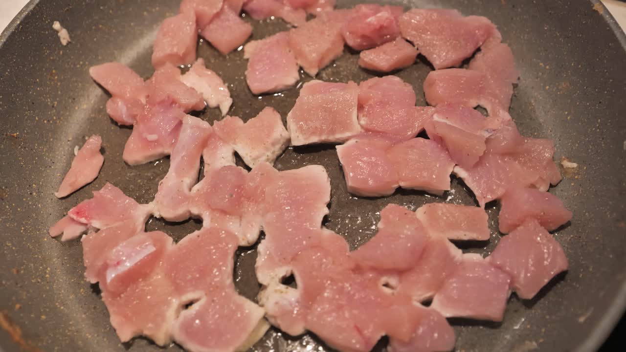 Overhead shot of turkey fillets frying on a pan with slightly tilted angl - 4K.