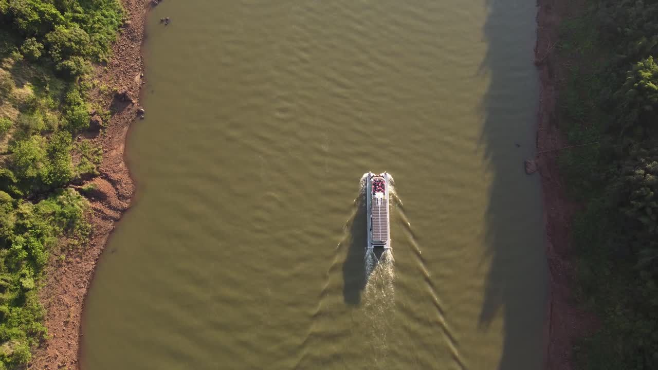 imágenes aéreas dinámicas de arriba hacia abajo que vuelan junto al barco turístico junto al río iguazú en uruguay