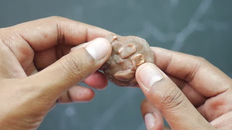 close-up of hands holding a chocolate candy