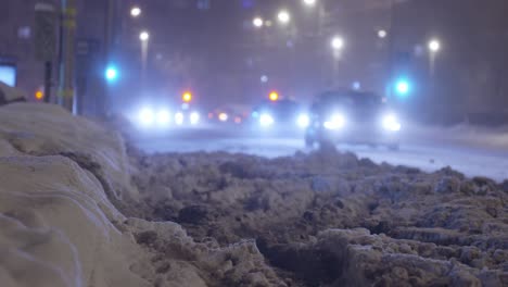 tráfico nocturno en la carretera helada de invierno en la ciudad, vista de ángulo bajo en los faros