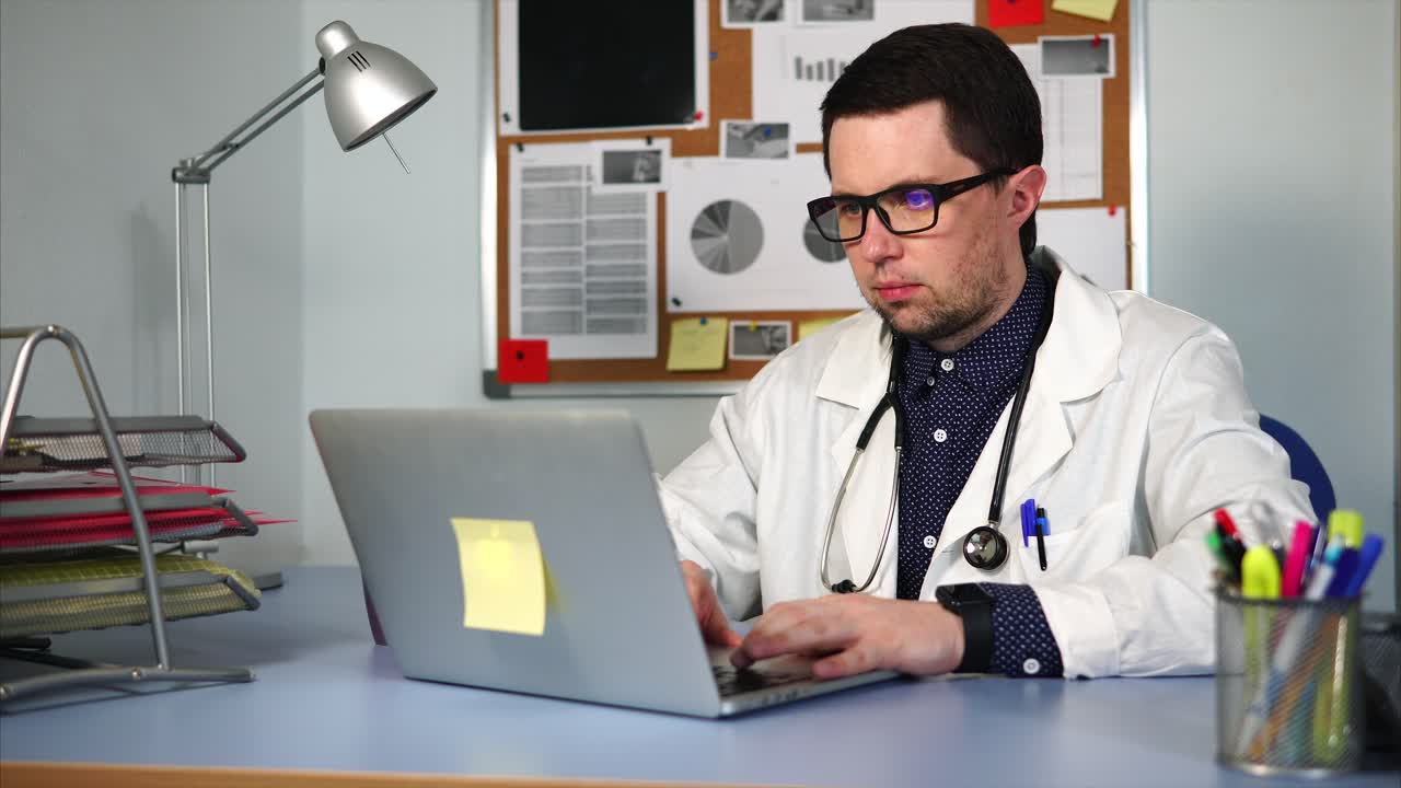 médico trabajando en una computadora portátil en la oficina