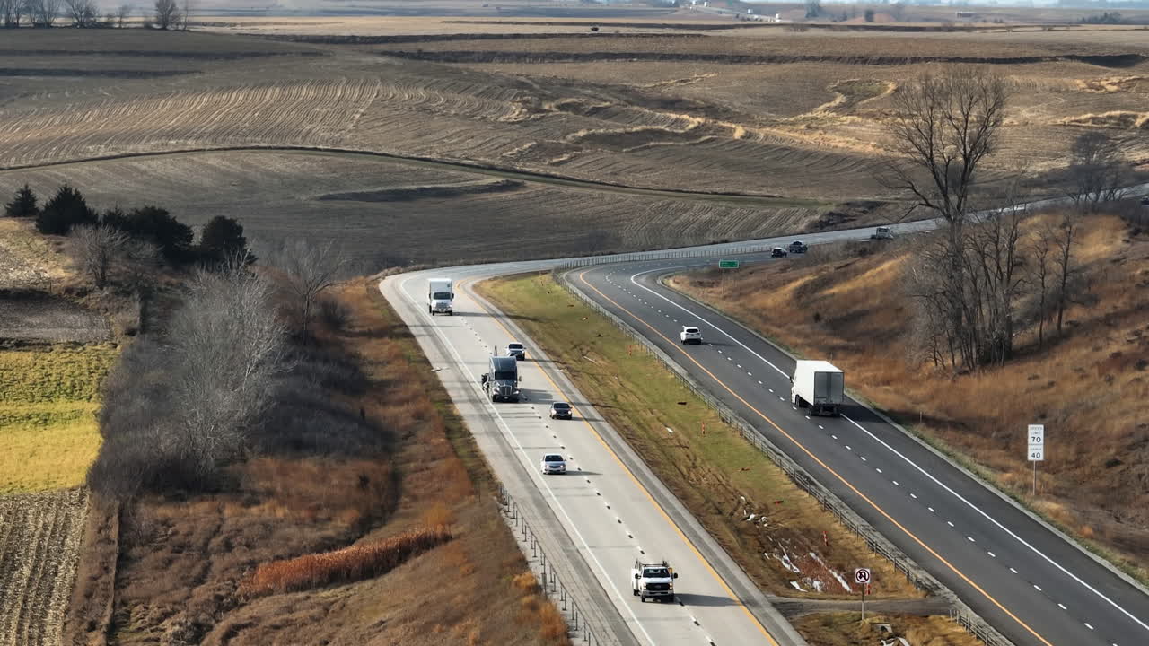 Concetto di logistica e trasporti: Camion pesanti su un'autostrada rurale divisa.