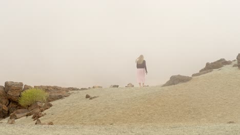 mujer solitaria caminando en la niebla profunda en el desierto del parque nacional de teide