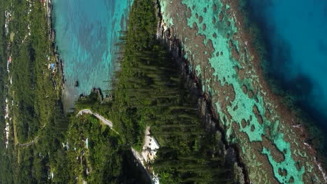 aerial ascending shot revealing amazing coral bay beach and tadine wharf, on maré island, new caledonia