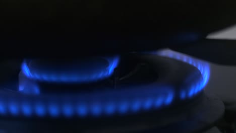 macro shot of blue flames on kitchen gas stove burner