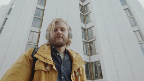 portrait of man in wireless headphones on street