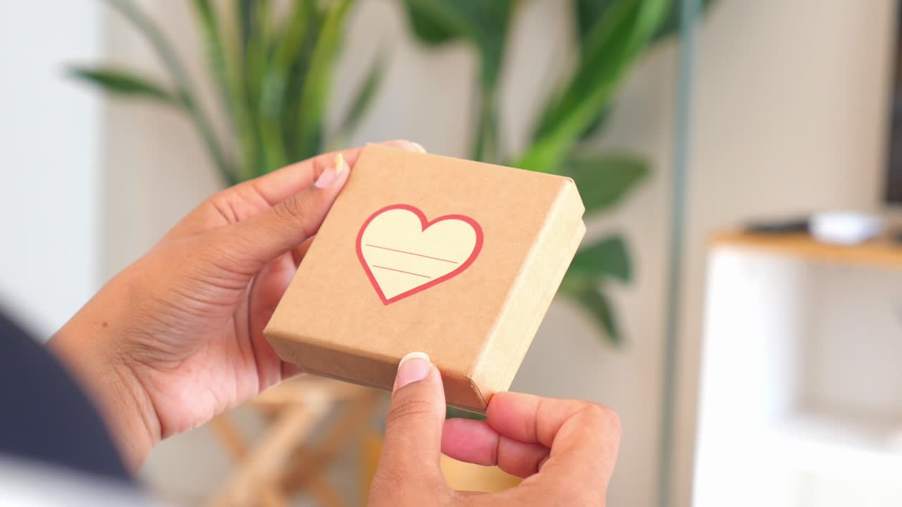 Hands holding a gift box with a heart