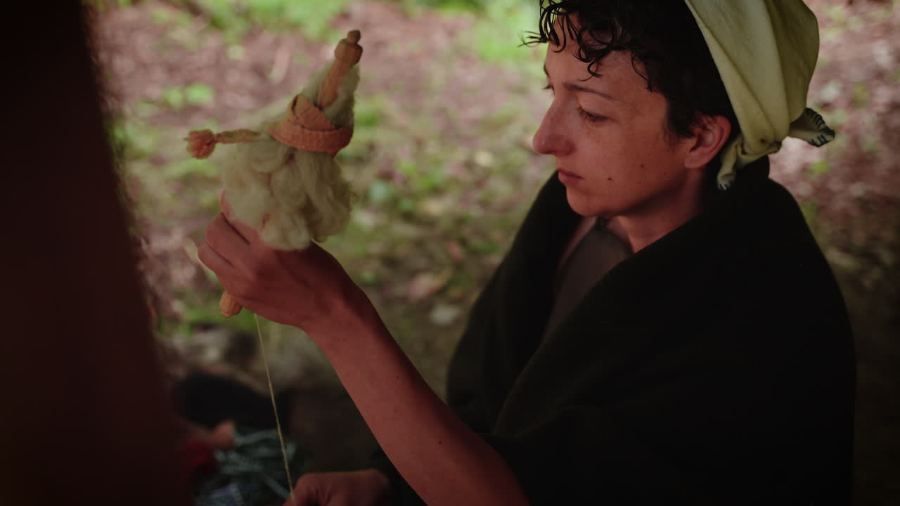 Woman Spinning Wool Outdoors