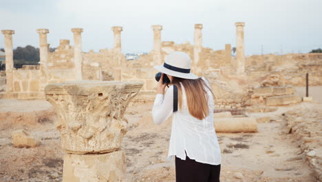 woman photographing ancient ruins