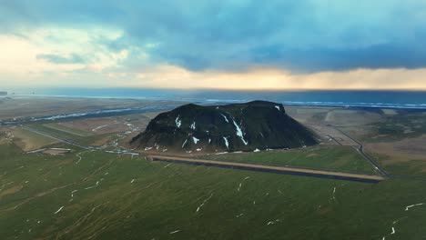 aerial landscape view of petursey mountain, iceland, with a dramatic cloudscape, at sunset