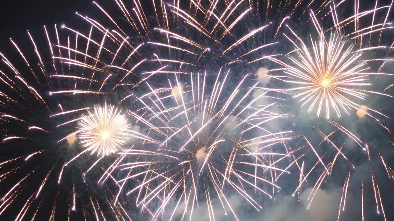 迫撃砲が砲弾を発射し、夜空に菊型の花火が上空に広がり、煙が漂う。