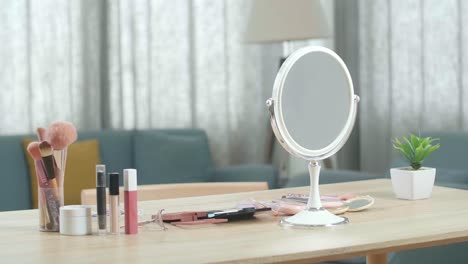 una vanidad con muchos cosméticos y espejo está en una habitación en casa
