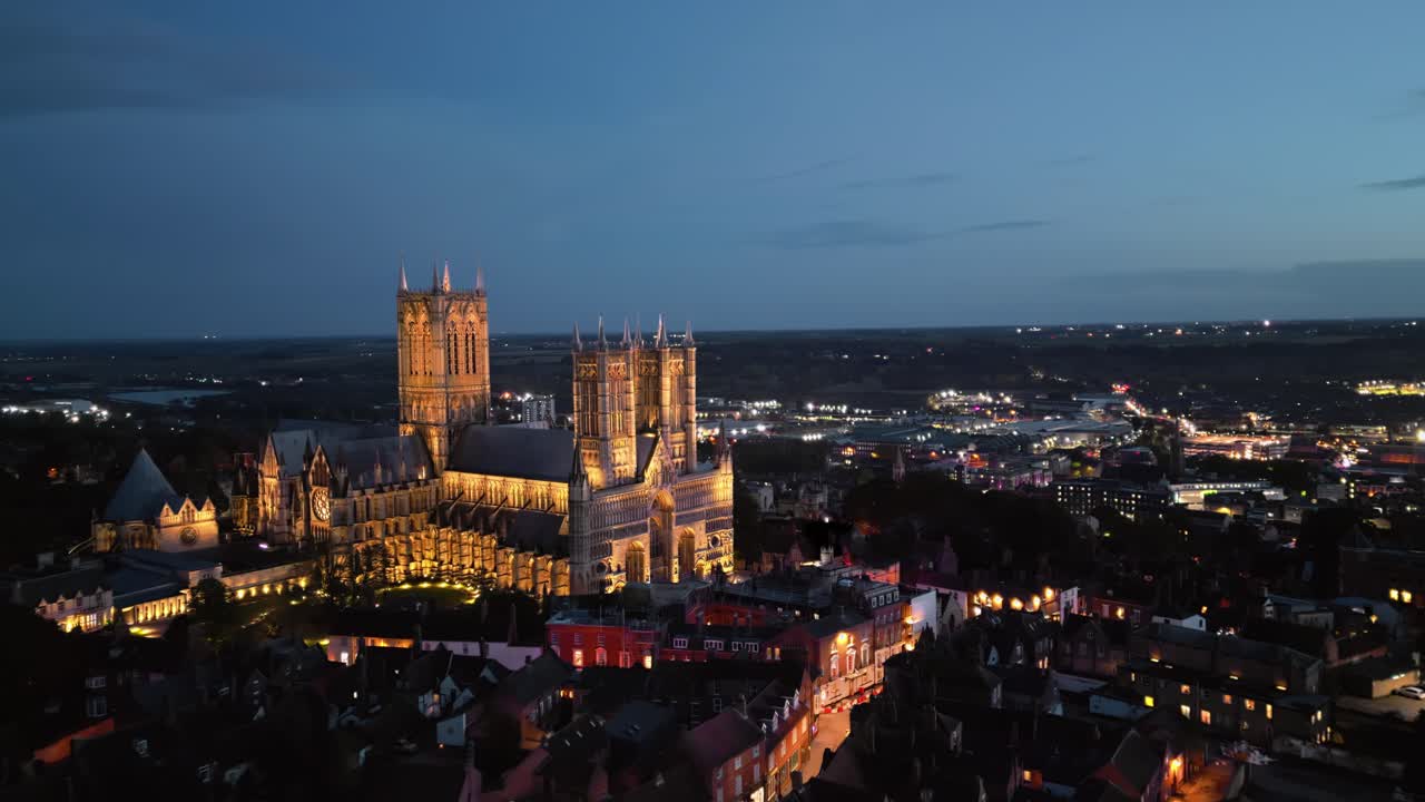 Luftdronevideo fanger den berømte Lincoln Katedral i Lincolnshire, Storbritannien, i skumringen, der fremviser dens majestætiske gotiske arkitektur med belysning