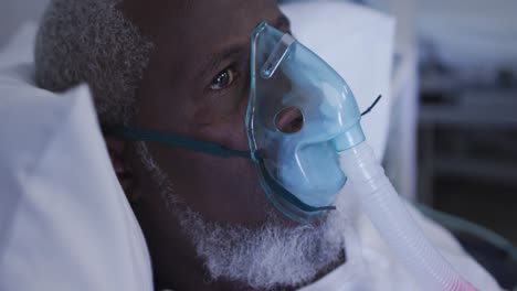 african american male patient in hospital bed wearing oxygen masks