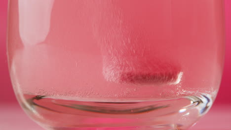 pink tablet dissolving in water