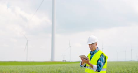 engineer using digital tablet when doing wind turbine inspection