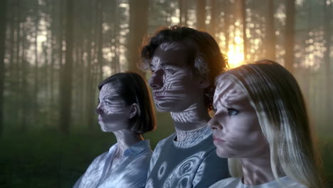 people with projected light patterns in a mysterious forest