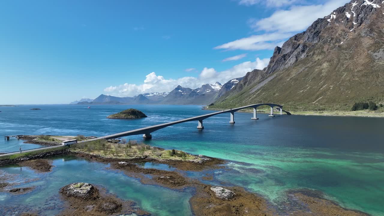 Cinematic aerial showing bus crossing the scenic Gimsoy bridge in Lofoten islands, Norway