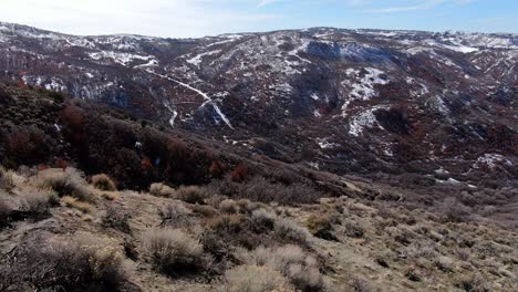 BEAUTIFUL-VIEW-OF-UTAH-MOUNTAINS-GOING-DOWN-HILL-WITH-DRONE