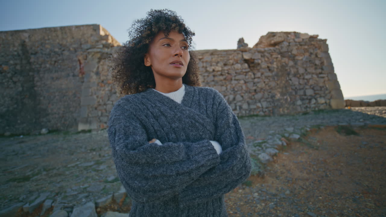 Pensive woman standing autumn beach wearing sweater closeup. Girl feeling cold