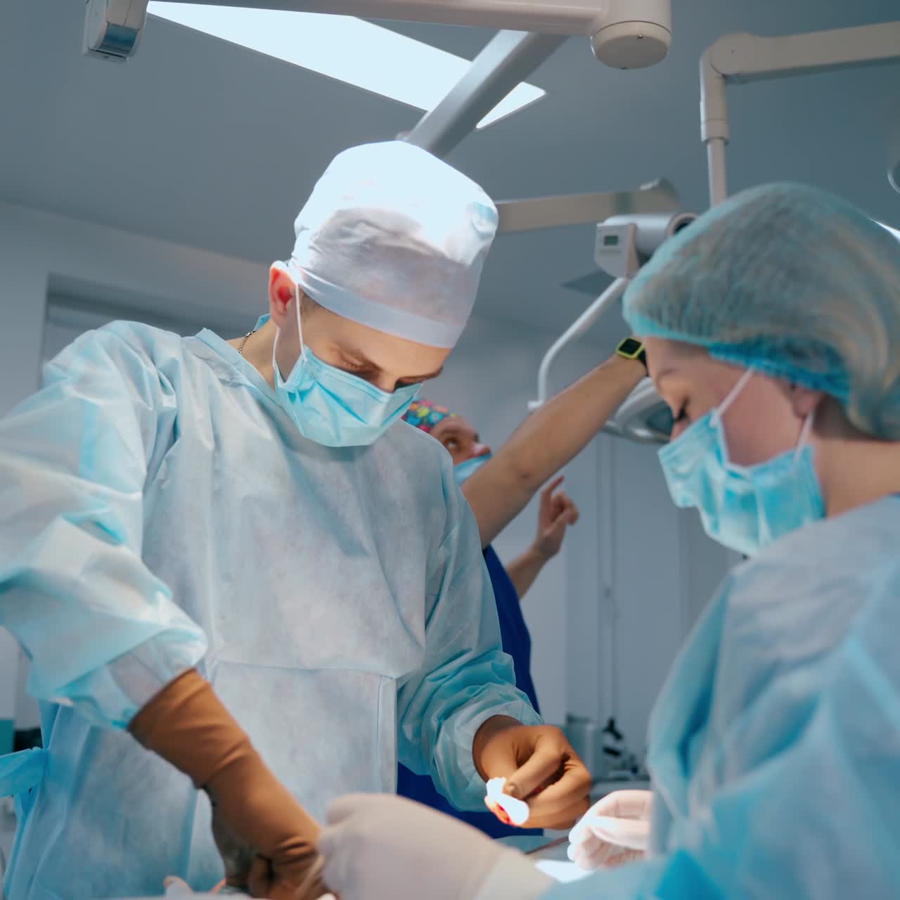 Surgical department. Doctor and assistant performing an operation in modern operating room. Health care concept.