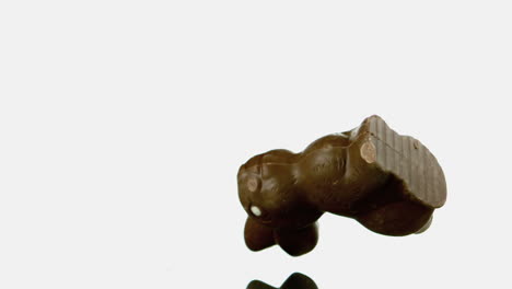 conejo de chocolate cayendo sobre una superficie blanca