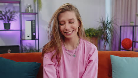 close-up portrait of happy smiling caucasian woman in hoodie, looking at camera, celebrate good news