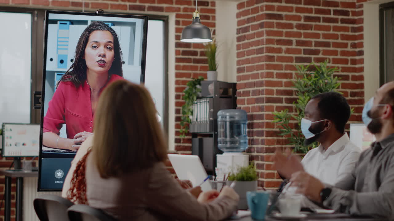 People with face mask talking on teleconference call to woman