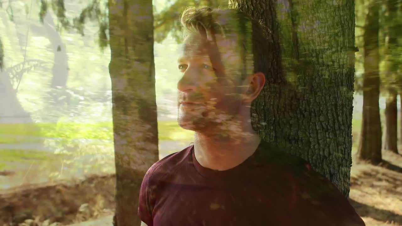 hombre apoyado en un árbol