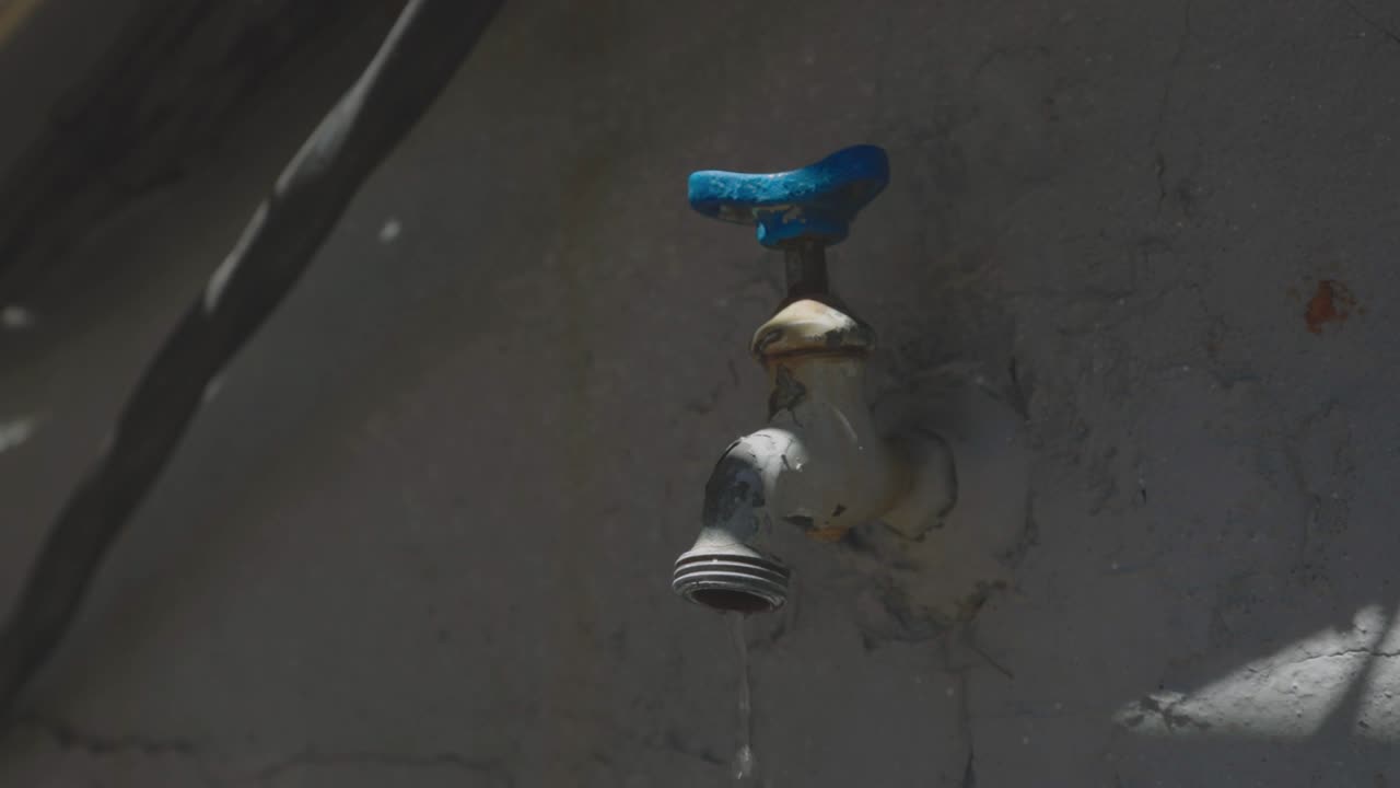 A Human Hand Slightly Turning Off The Faucet Outdoor - close up