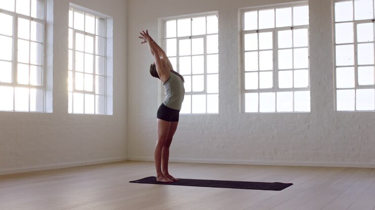 donna sana di yoga che allunga il corpo flessibile godendo dello stile di vita fitness praticando le pose in allenamento in studio sul tappetino per esercizi all'alba