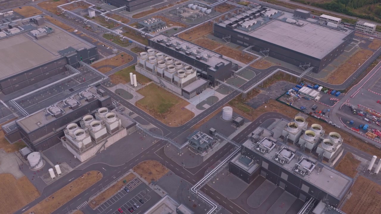 Large industrial complex featuring multiple buildings with advanced cooling towers on the rooftops. Essential infrastructure for a modern data center