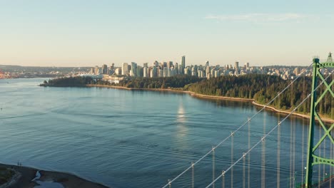 drone aerial shot flying towards vancouver cityscape passing the lions gate bridge