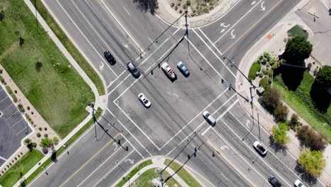 intersection traffic with cars driving on city road - aerial overhead top down view