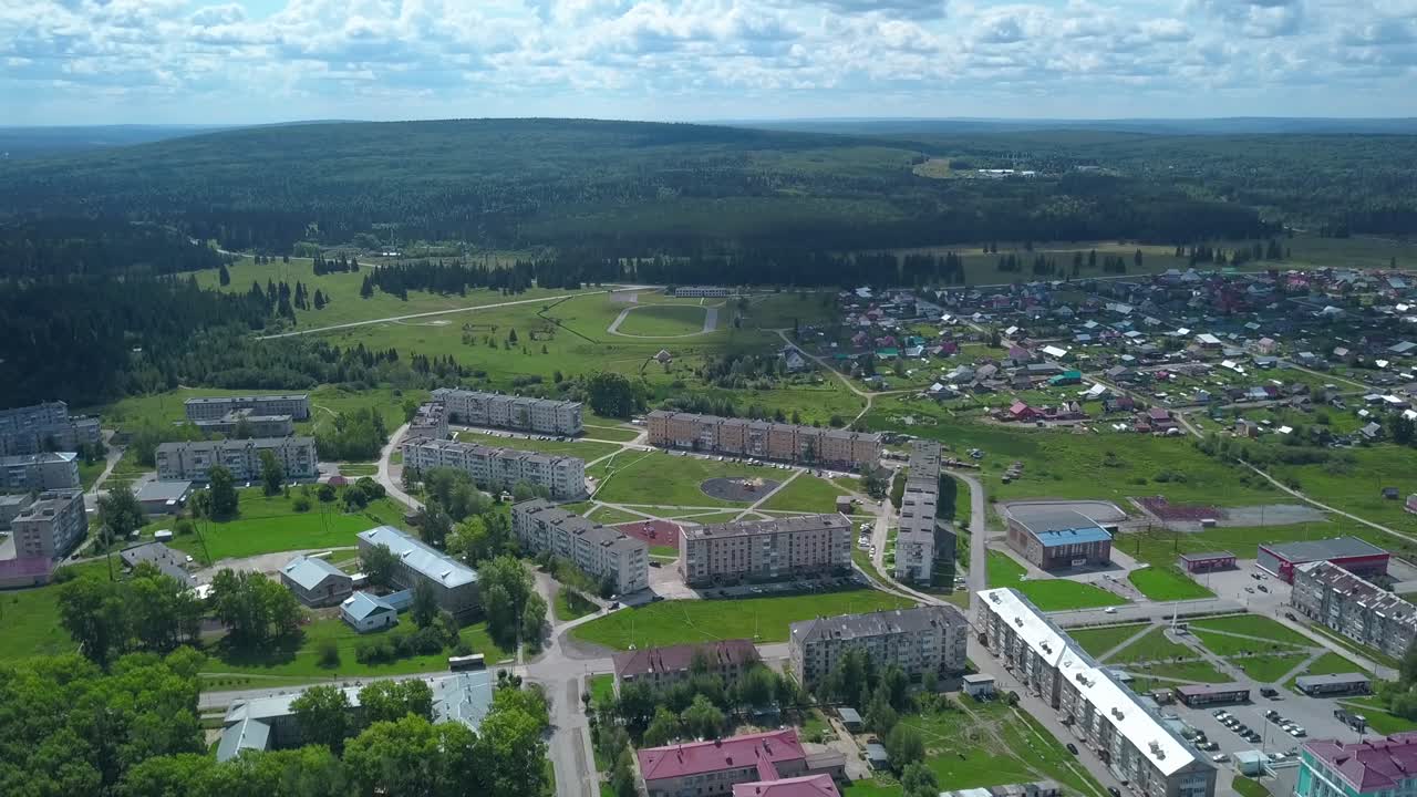 воздушный вид города, расположенного в долине с окружающим лесом