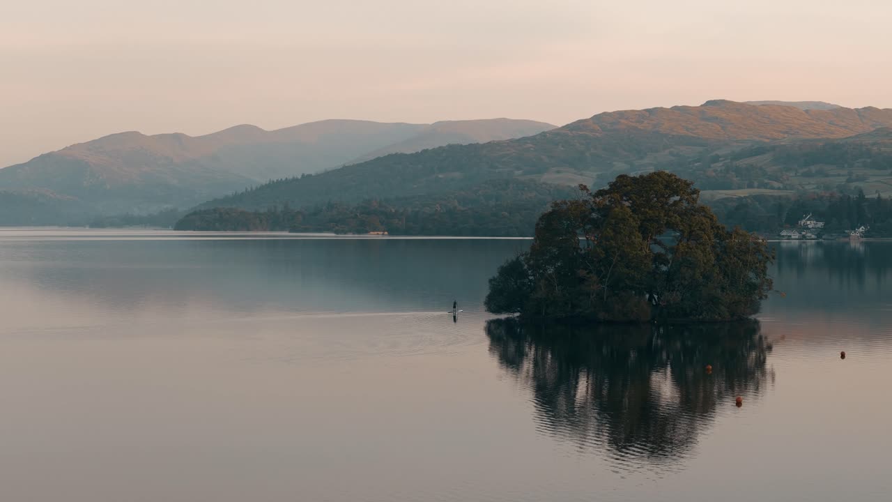 Serene Sunset over Lake with Island and Stand Up Paddleboarder