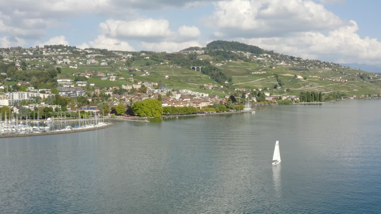 Volando verso la città di Lutry, passando accanto a una barca a vela. Stagione estiva, Lutry, Lavaux – Svizzera.
