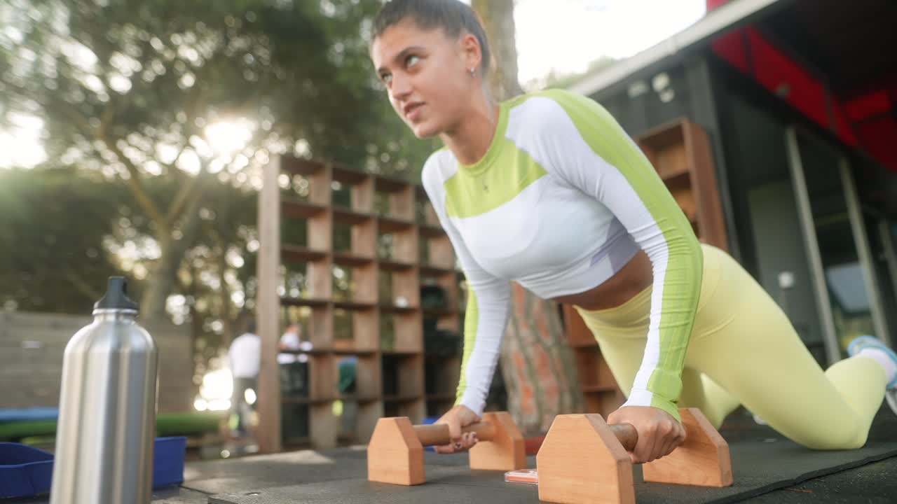 Giovane donna determinata che fa flessioni in una palestra all'aperto
