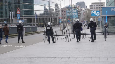 unrecognizable riot police in full riot gear cordon off a street to protect the european district in brussels, belgium