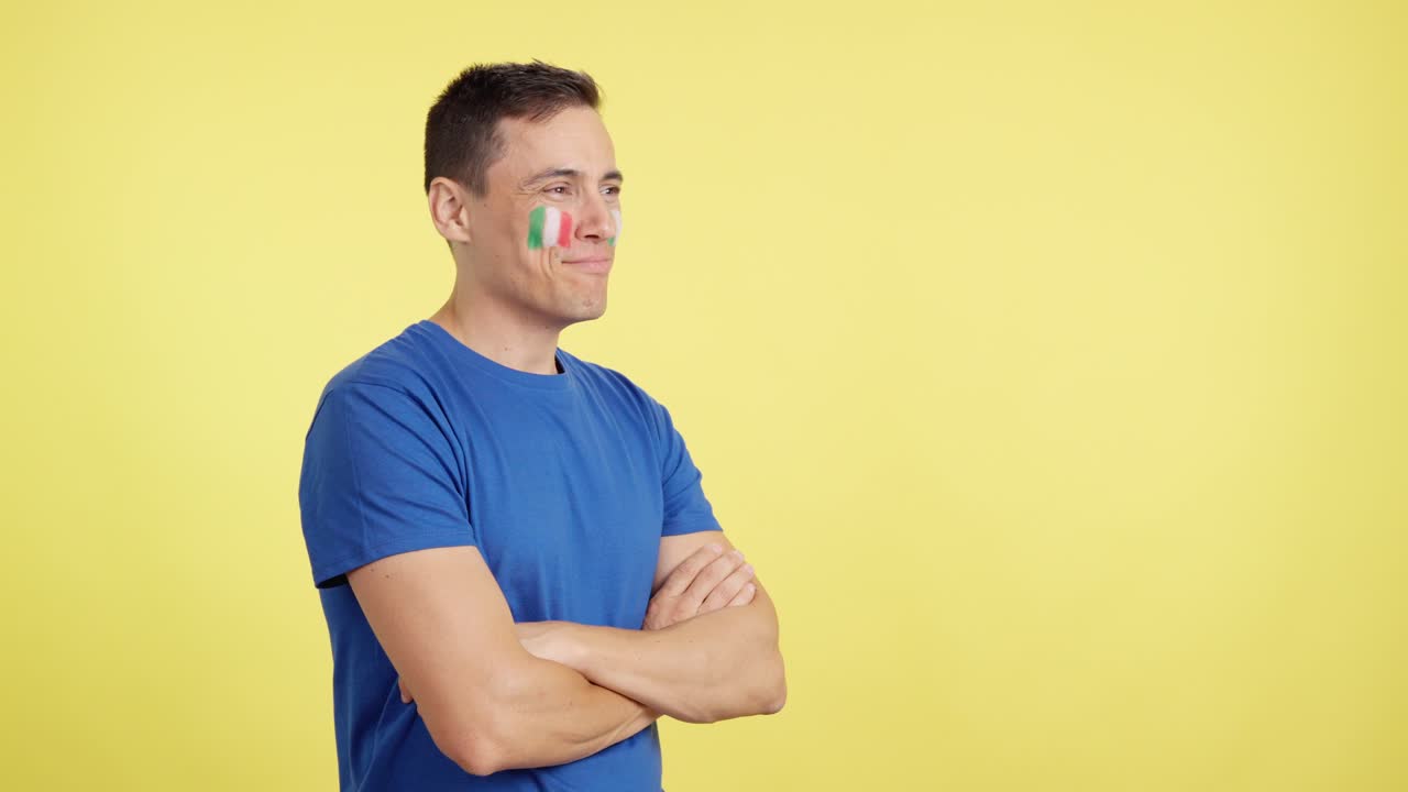 Happy man with italian flag painted on face looking away