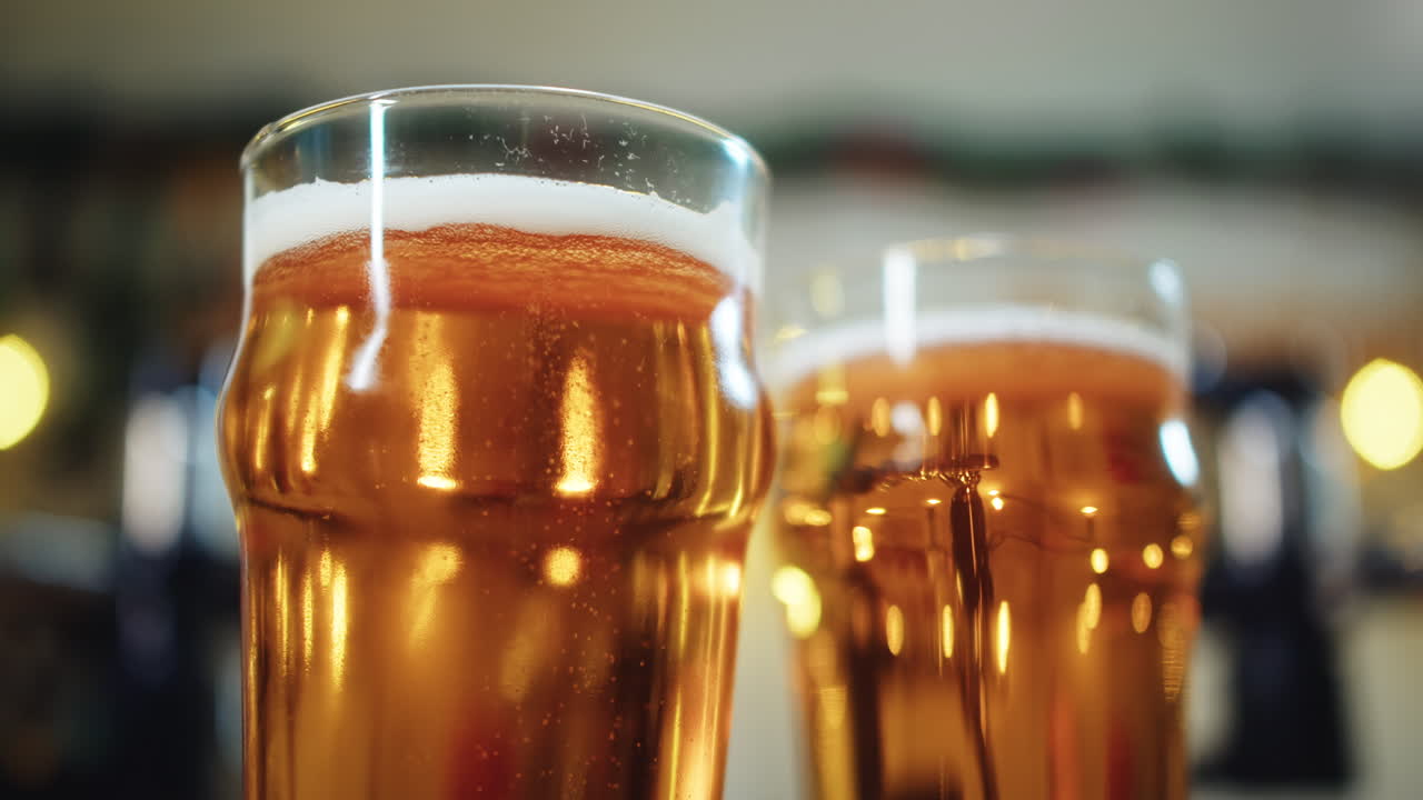 Primo piano di due bicchieri di birra dorata con bollicine