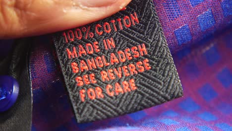 close-up of a clothing tag with "100% cotton made in bangladesh see reverse for care"