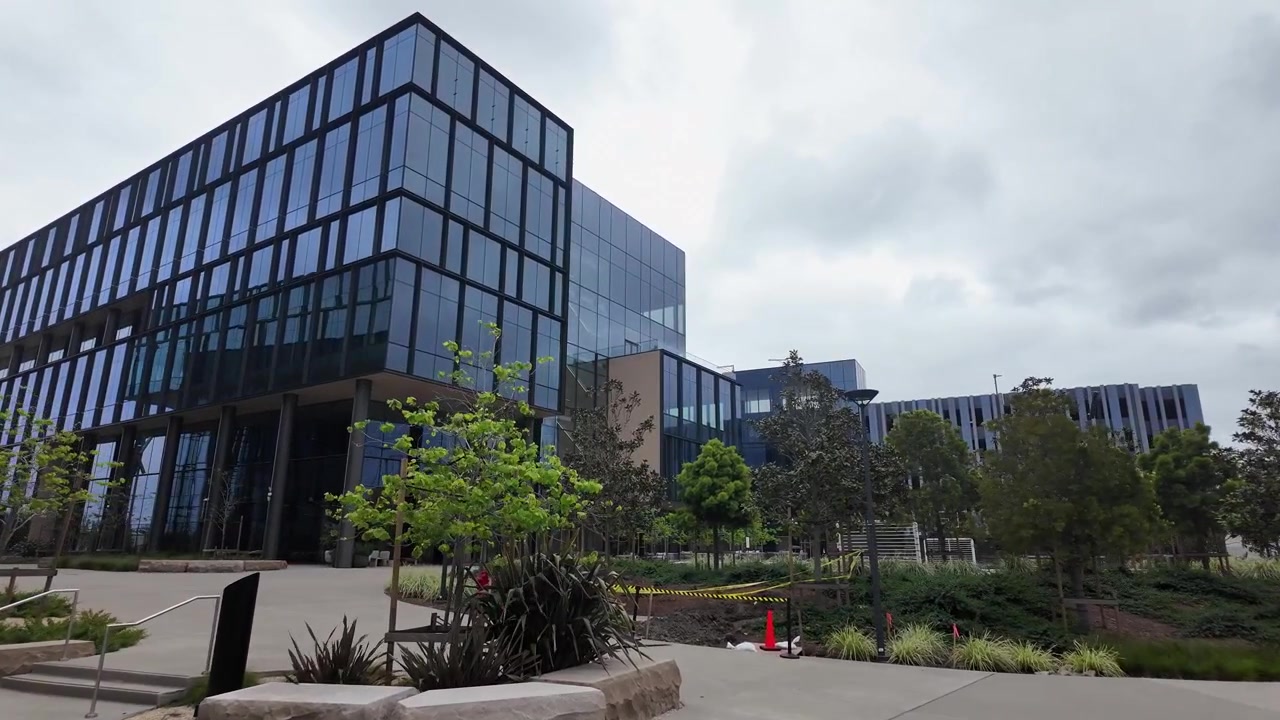 Architettura moderna di un edificio di ricerca per laboratorio medico con un giardino esterno paesaggistico nel polo biotecnologico di South San Francisco, California, in una giornata nuvolosa.
