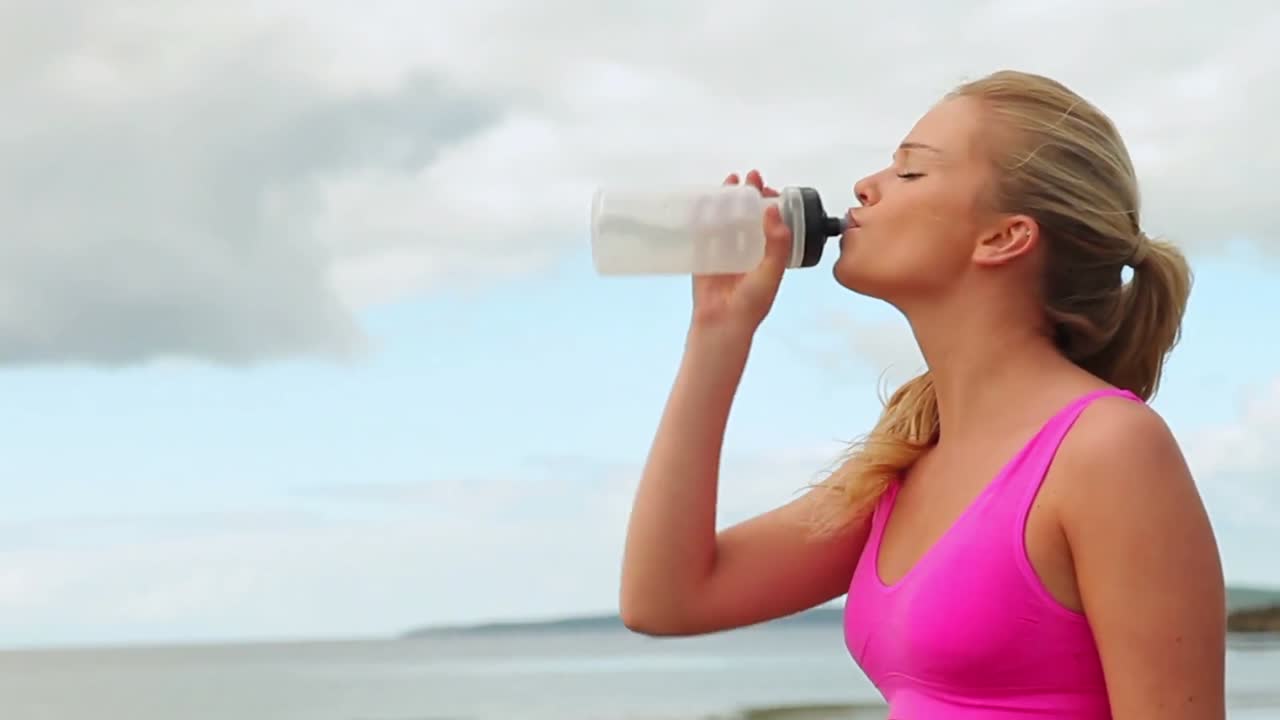 Fit bionda jogging sulla spiaggia