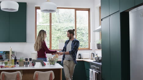 Feliz-Pareja-Diversa-Bailando-En-La-Cocina-De-Casa,-En-Cámara-Lenta