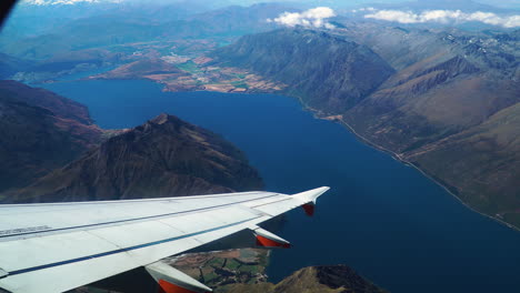 tranquilo lago azul y cordillera visto desde la ventana del avión volando en el cielo