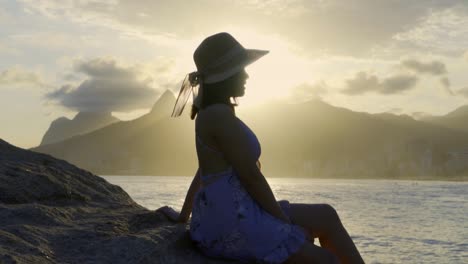 beautiful asian woman watching a sunset at ipanema beach in rio de janeiro