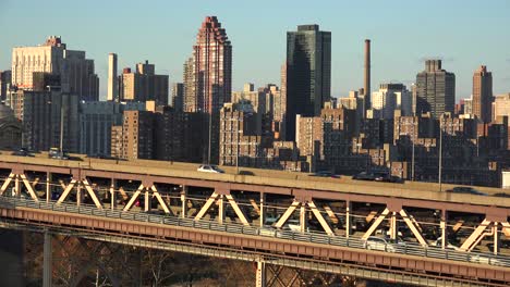 wide shot of the queensboro bridge and traffic with the new york skyline background