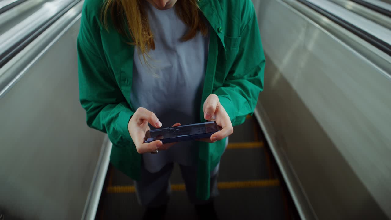 Person Using Smartphone on Escalator